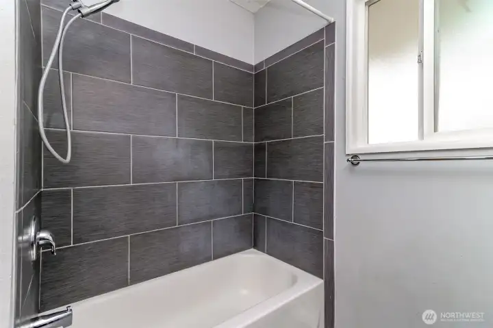 Beautiful tile surround for tub/shower in main bathroom.