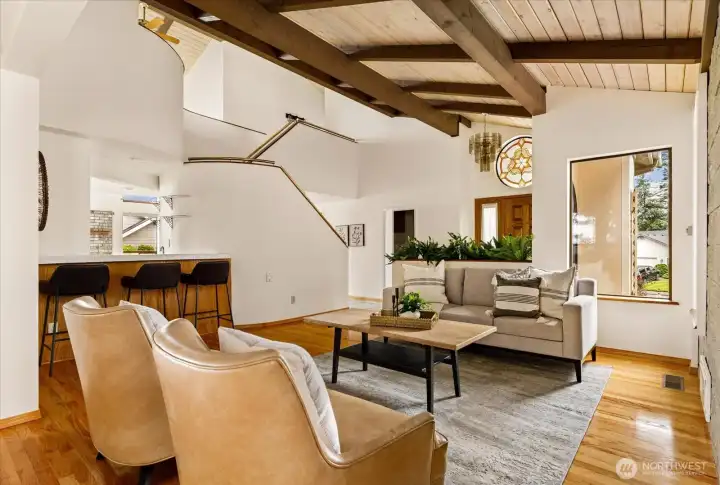 Living room off entry with architectural roof lines and wood floors