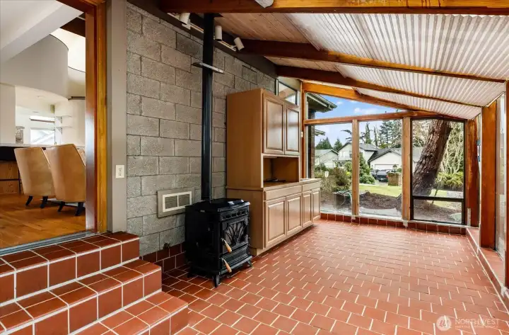 Sunroom with opening to large partially fenced yard off living room