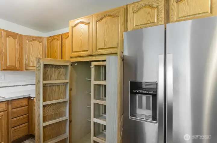 Space saving pull out pantry offers loads of organized storage.