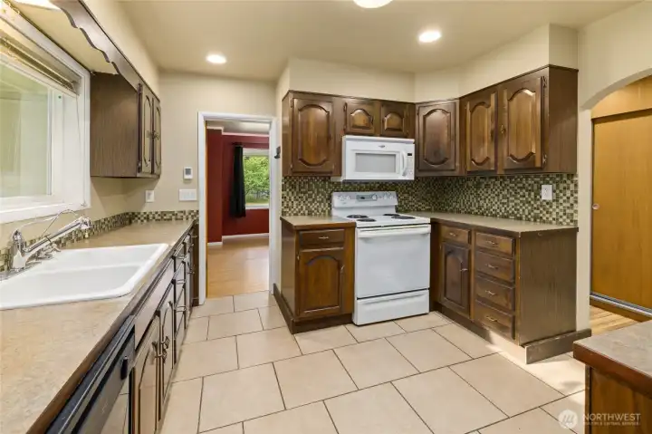The kitchen offers ample workspace, tile flooring, and a convenient location just off the dining area.
