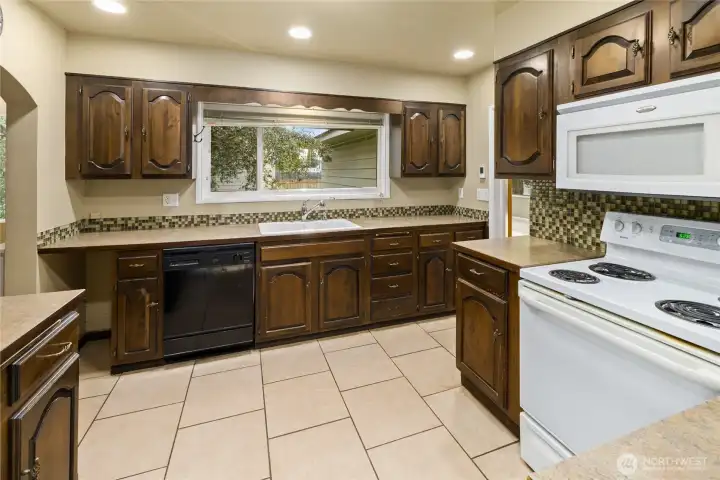 The kitchen features abundant cabinet storage and a large window that fills the space with natural light.