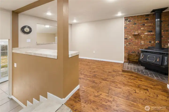 Another versatile flex space featuring a cozy wood stove, ideal as a den, home office, or guest sleeping area.