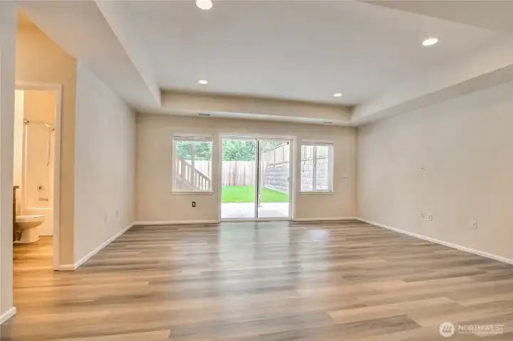 Lower level living room with sliding doors to the concrete covered patio and backyard. Lower level living room with sliding doors to the concrete covered patio and backyard.