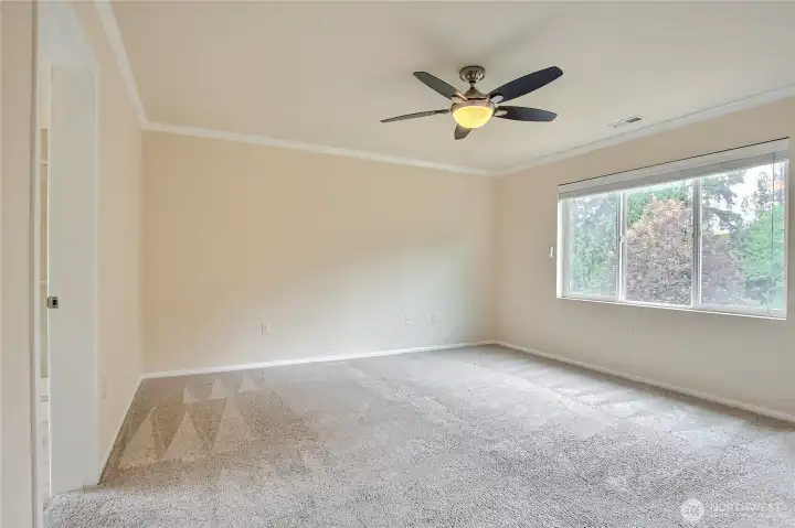 Primary bedroom with ceiling fan and view of backyard. Primary bedroom with ceiling fan and view of backyard.