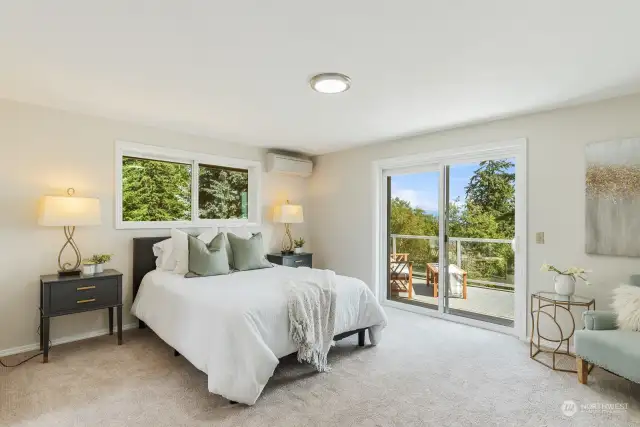 Primary bedroom brings nature in with access to the deck.