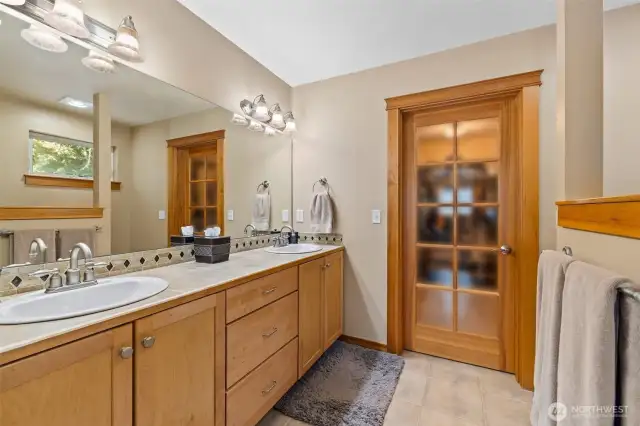 Gorgeous double vanity, soaking tub, separate shower, primary bath open to well-organized walk-in closet.
