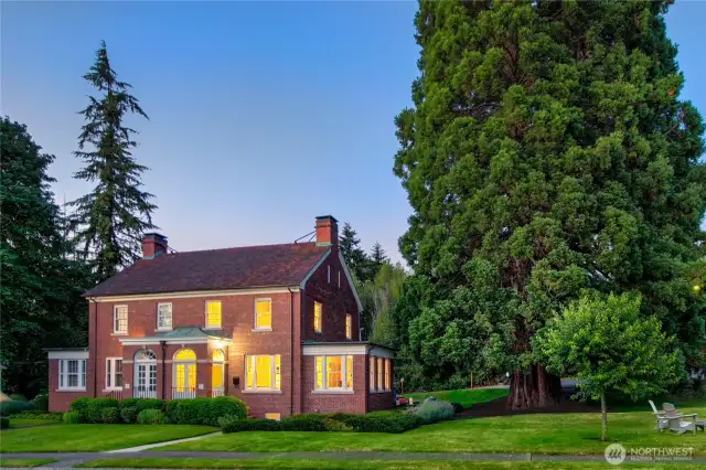 Beneath the sheltering limbs of a century-old sequoia, this 1935 officer’s residence stands in stately repose—its brick façade glowing softly as dusk settles over Discovery Park. A home once shaped by duty, now devoted to sanctuary.
