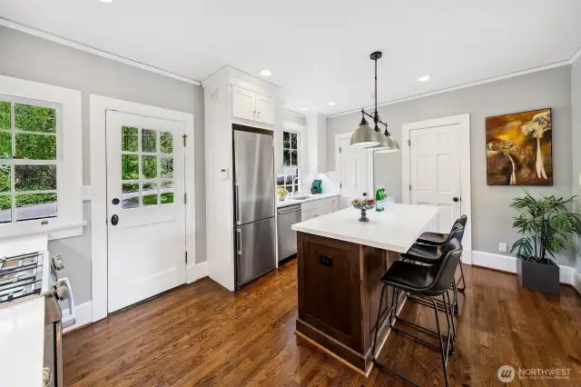 Light dances across oak floors and Carrara surfaces in this elegant, functional kitchen—designed to serve both heritage and today’s rhythms. Step through the glass door to the outdoor living area, where meals extend into nature and daily life is always touched by the trees.