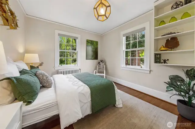 One of three upstairs bedrooms, this tranquil corner offers leafy views and timeless charm. Built-in shelves whisper of stories held and treasures kept—inviting rest, reflection, or the gentle murmur of a child's dreams.
