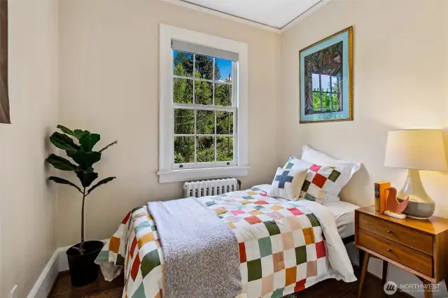 A sun-dappled nook perfect for a child’s room or quiet retreat, this bedroom is framed by verdant views and warmed by simple pleasures. Here, a handmade quilt, a favorite book, and the hush of the forest offer comfort beyond words.