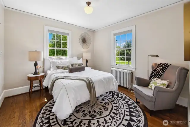 Framed by twin windows that open to sky and green, the primary bedroom exudes quietude and clarity. Oak floors, soft light, and historic proportions create a restful sanctuary—where each day begins with birdsong and ends beneath the stars.