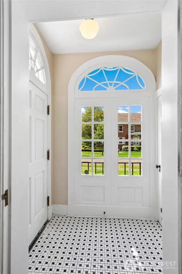 A gracious vestibule welcomes you with original tile underfoot and filtered light through a fanlit transom—details that whisper of 1930s craftsmanship. From the moment you arrive, the home invites you to slow your pace, shed the day, and step into a quieter rhythm shaped by tradition and tranquility.