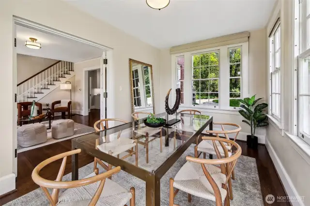 Wrapped in windows and bathed in natural light, the former sun porch now serves as an intimate dining room—an ideal perch for morning coffee or candlelit dinners. Just beyond the glass, Discovery Park breathes and rustles, lending every meal a sense of ceremony and calm.