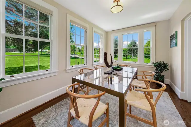 Sunlight pours through walls of glass, framing the sequoia-dotted lawn like a living painting. This luminous dining space, once a sun porch, captures the essence of Fort Lawton living: rooted in history, immersed in nature, and filled with everyday grace.
