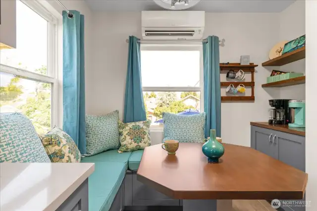 Quaint window niche offers a cozy banquette with table and custom cushions, and a convenient coffee station