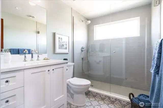 Fully remodeled with exceptional style, the upstairs bath with porcelain tiled walk-in shower, glass doors and tiled flooring