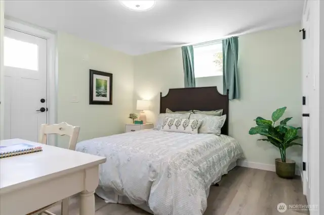 Lower-level bedroom with soothing faint green walls offers a separate outside entrance and is adjacent to 3/4 bath