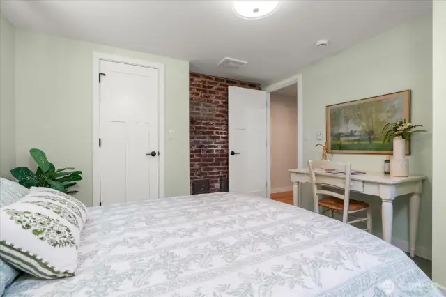 Appointed with two closets, the lower-level secondary bedroom accommodates a queen-sized bed and offers a secret passage to family room