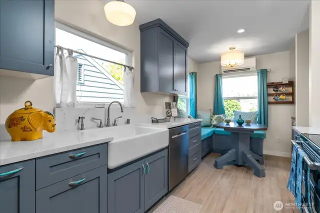 Well-appointed kitchen with deep trough sink under window, and abundance of custom cabinets and quartz counterspace