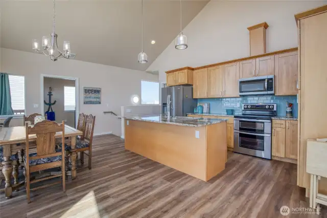 Kitchen features granite countertops, stainless steel appliances, and a gorgeous tile backsplash that compliments the ocean views.