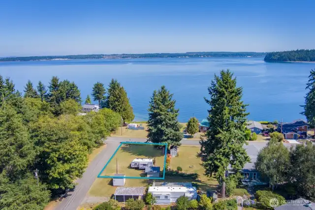 This beautiful corner lot is yours. The outline shown here is a visual photo estimation but corners are marked onsite. There is now a home being built on the lot closer to the water. This photo was taken a year ago by the seller.