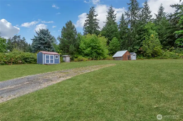 Enhanced driveway shot with out buildings and RV parking space