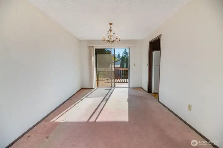 The dining room adjoins with the kitchen on the right and features sliding glass doors to a large deck and backyard.
