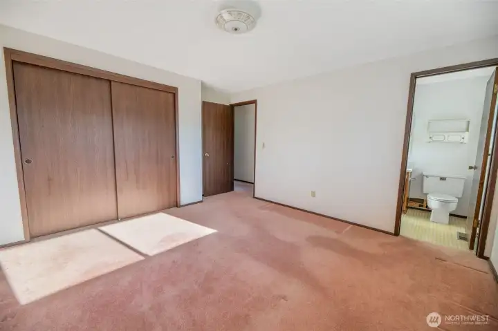 Another view of primary suite towards ensuite bath and large closet.
