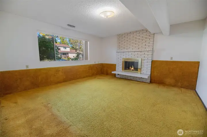 Spacious main level family room features cozy wood burning fireplace. Flames are virtual.