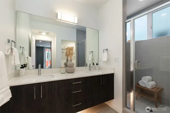 Double vanity bathroom with a walk-in shower, large window and a tucked away loo.
