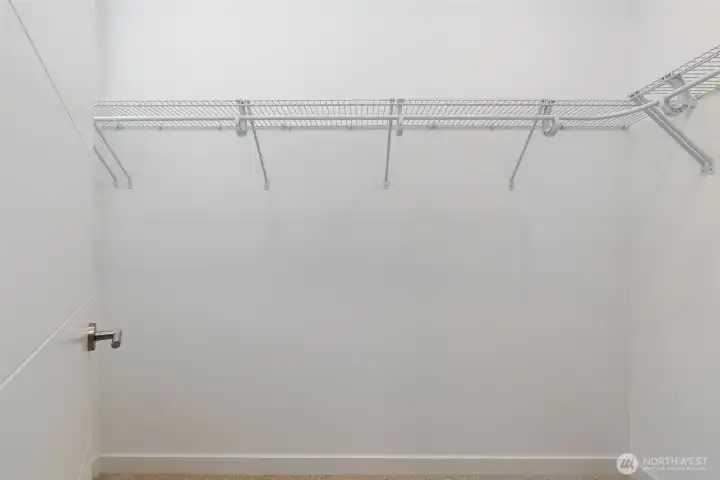 Walk-in closet off primary suite. On the other side of the closet door to the left is a lovely window for natural light while in the closet.