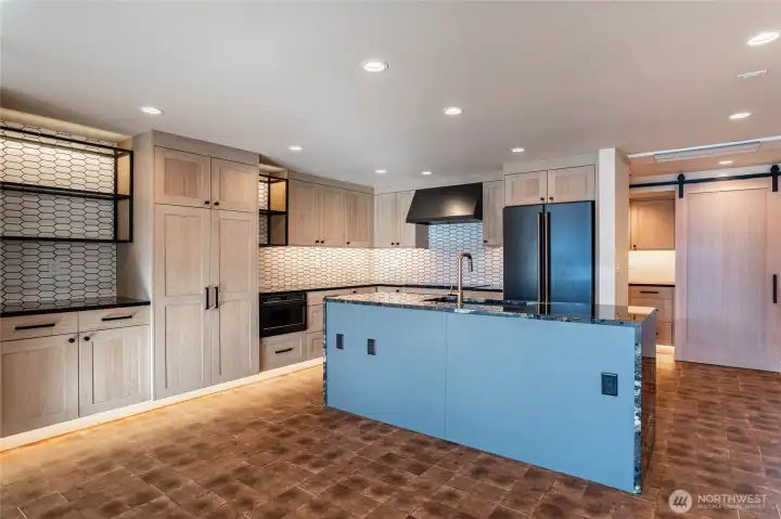 Modern kitchen counters and luxury appliances accented by automatic undercounter and undercabinet lighting. Ample kitchen storage space.