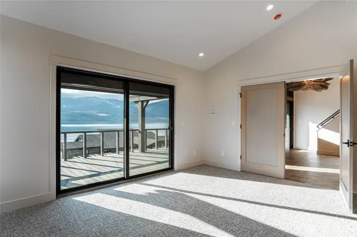 Primary bedroom with large glass sliding door opens to the large deck.