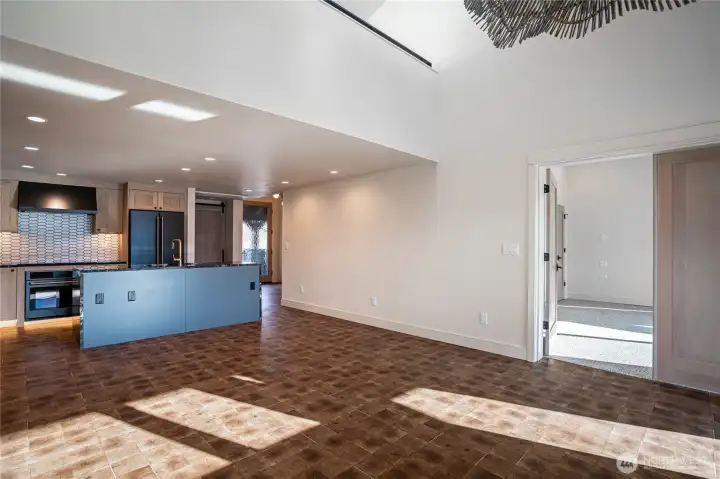 Spacious living room with cathedral ceilings, stairs to loft area, dining area, and open concept kitchen .