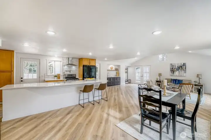 The inviting open floor plan supports effortless everyday living and entertaining. The expansive layout flows seamlessly toward a nearby wet bar, creating the perfect setting for hosting.
