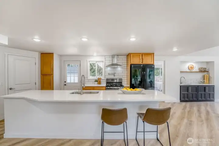 Step into a beautifully designed kitchen centered around a striking 12ft quartz island, an entertainer’s dream with plenty of room to gather, dine & connect. The expansive layout flows effortlessly towards a nearby wet bar.