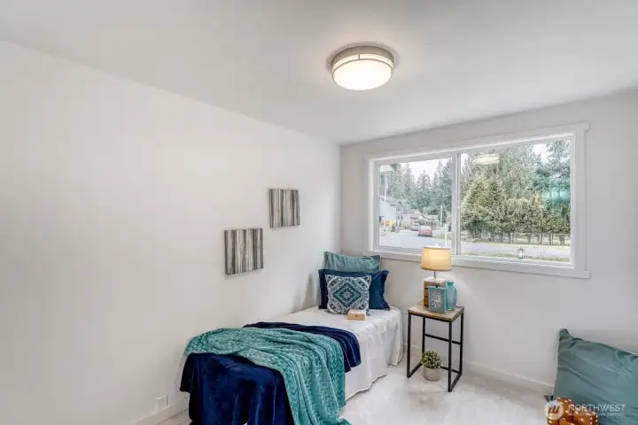 Bedroom#4. This fresh, light-filled bedroom welcomes you with its sunny disposition and airy ambiance. Generous windows invite natural light throughout the day, creating a warm and uplifting retreat.