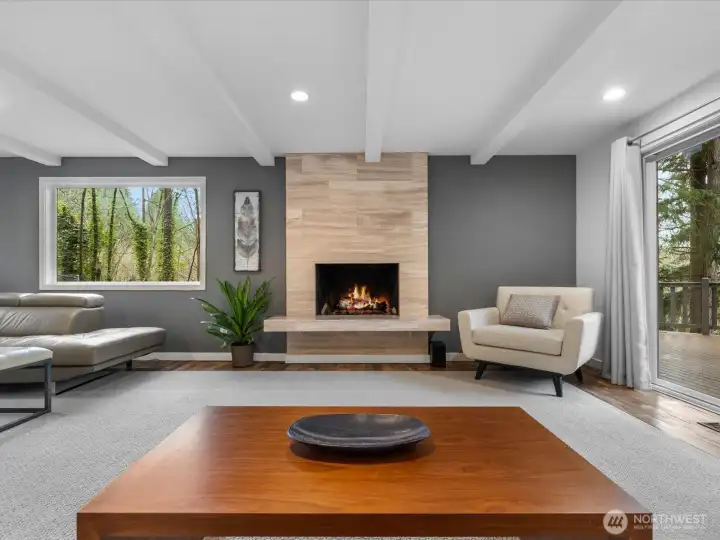 Travertine fireplace serving as a sophisticated focal point in the main living space. Enjoy the large picture windows inviting abundant natural light and frame the surrounding greenery.