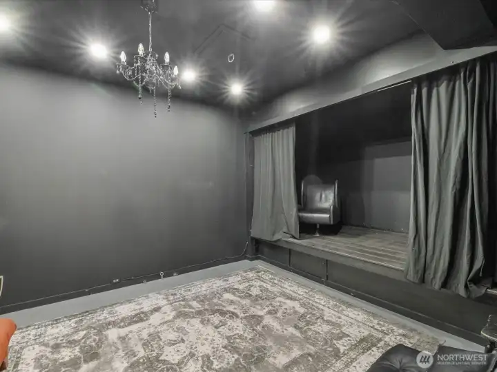 Versatile theater suite already wired featuring a raised stage, offering a space that easily transforms from a private cinema to a yoga studio or an exclusive lounge for creative expression.