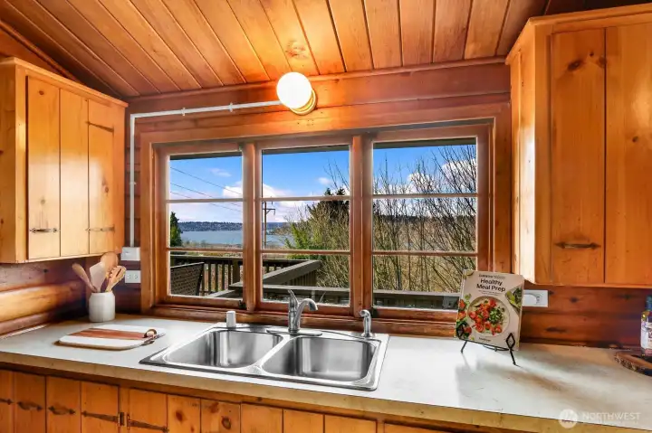 Oversized kitchen view window above sink, creates a cheerful place for food prepping and cleaning up after meals
