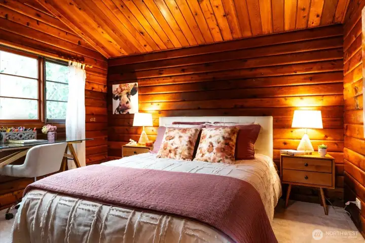 Plush, Light neutral carpeting contrasts nicely with warm wood walls, making the bedroom feel cozy