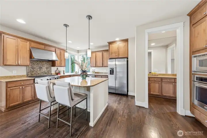 Kitchen with full height tile backsplash and slab granite countertops