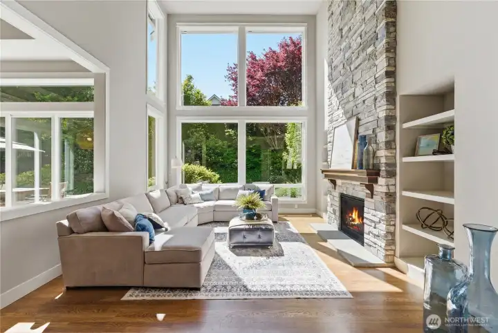 Step inside to soaring windows and a lush, uninterrupted green backdrop. Double-height ceilings bring volume and quiet drama to the family room