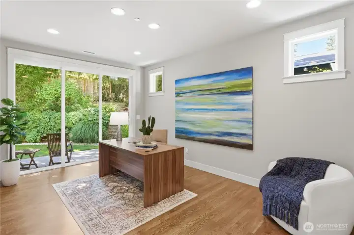 Just off the main-floor 3/4 bath, this private office opens to the outdoors through slider doors and is filled with natural light. Hardwood floors flow throughout the entire main level