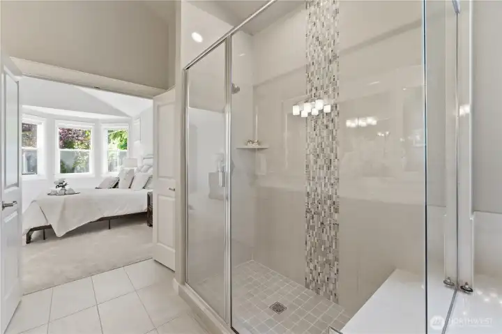 A beautiful walk-in shower featuring natural stone and detailed tile work