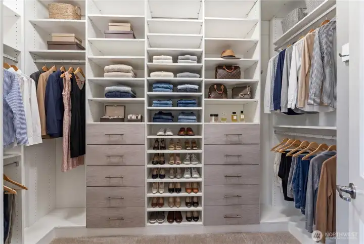 This beautiful walk-in closet, shown virtually staged, provides exceptional storage capacity and organization