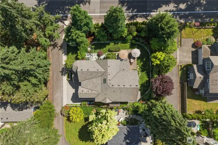Surrounded by mature evergreens and curated gardens, the home enjoys a uniquely private corner-lot presence