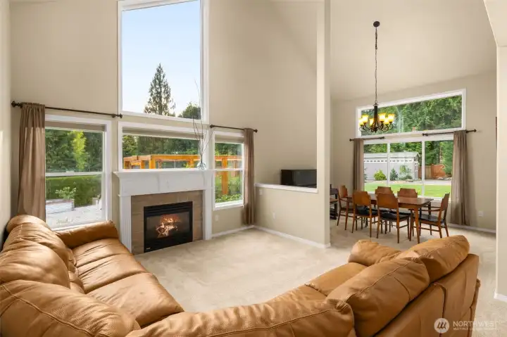 Soaring cathedral ceilings and windows in living room overlooking the garden and backyard.
