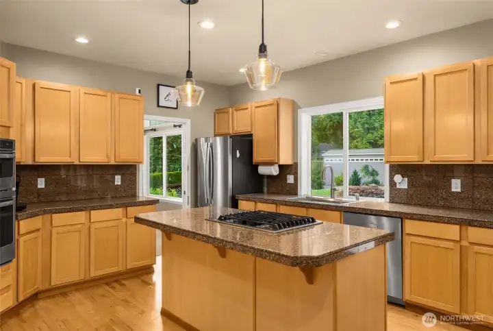 Open chef's kitchen with island cooktop and ample counterspace